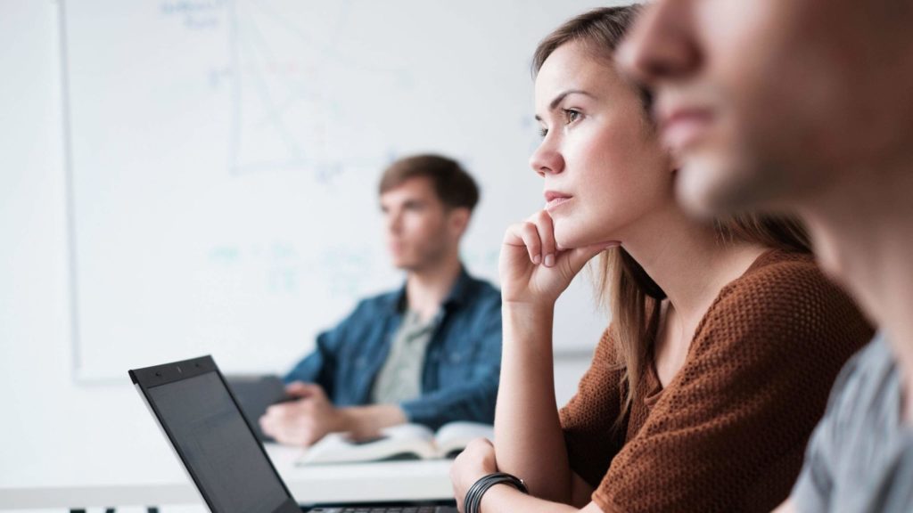 group of people attentively listening to something outside of the image