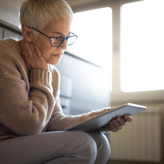 a sitting woman reading off her tablet