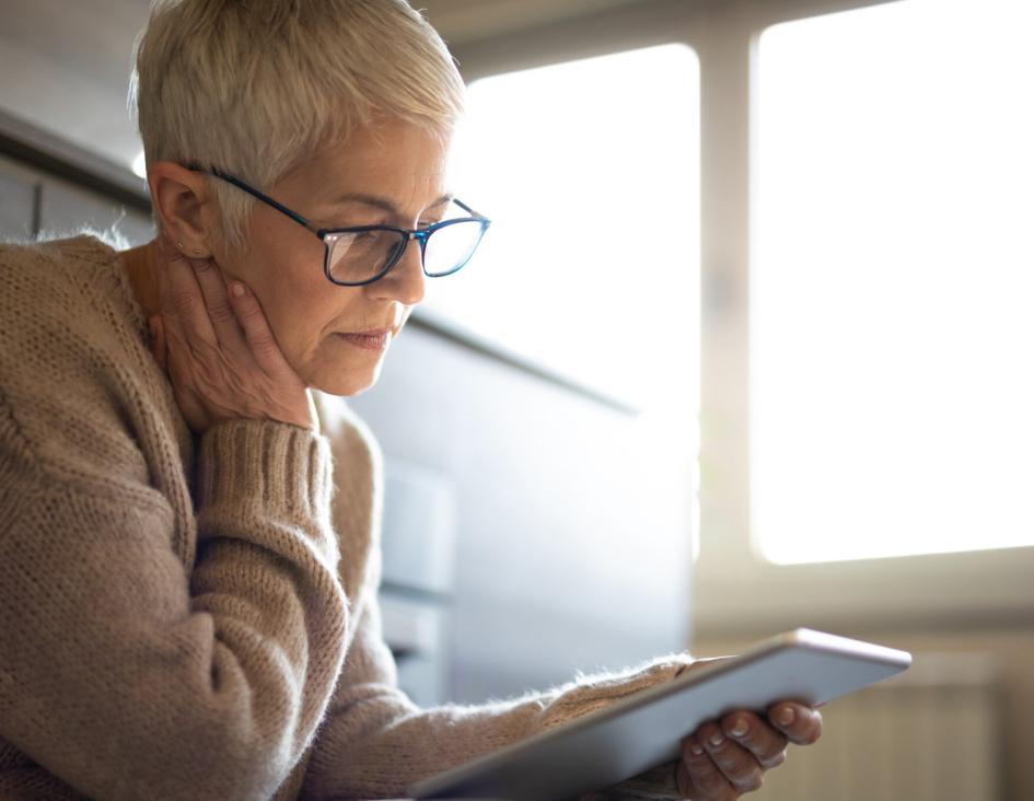 a sitting woman reading off her tablet